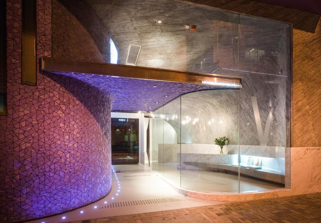 a lobby with a purple wall and a glass door at V Wanchai in Hong Kong