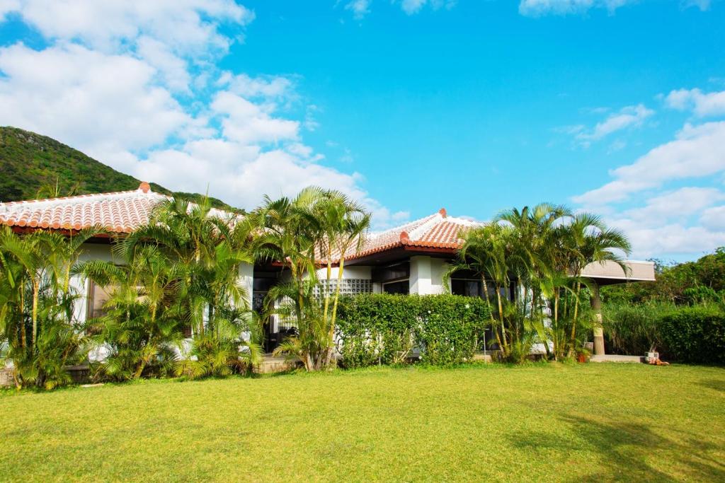 una casa con palmeras frente a un patio en Palm Villa Ishigakijima yugafu, en Ishigaki Island