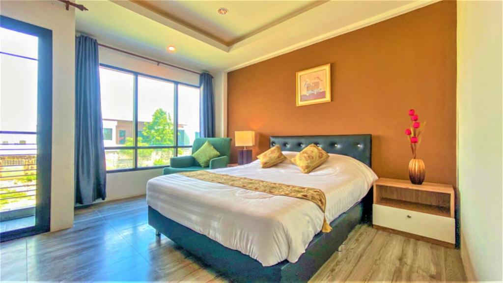 um quarto com uma cama grande e uma janela grande em Plearnwan Deluxe Mansion em Bangkok