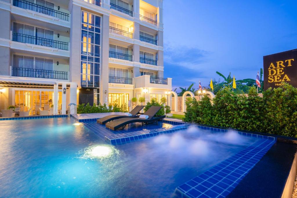a swimming pool in front of a building at Art De Sea Hua Hin in Hua Hin