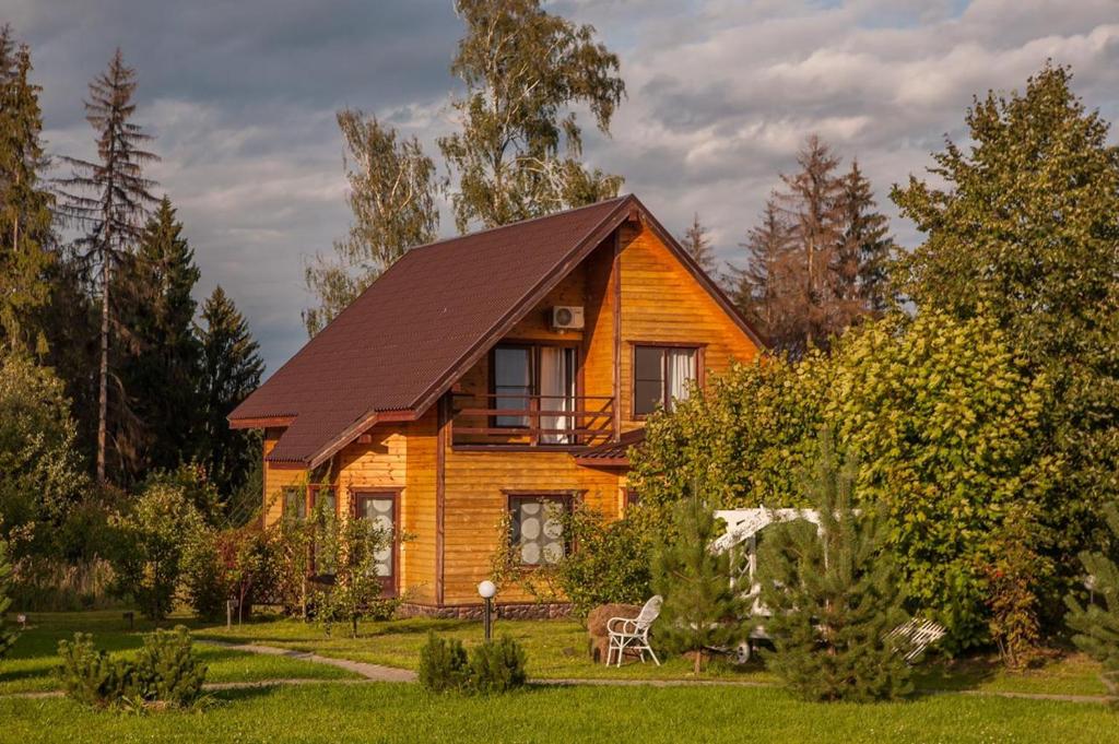 a wooden house in the middle of a yard at Tuchkovo SPA hotel in Tuchkovo