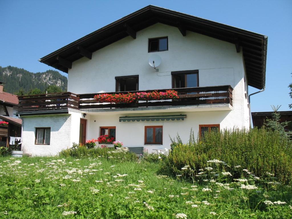 ein weißes Haus mit Blumen auf dem Balkon in der Unterkunft Haus Antlinger in Reutte
