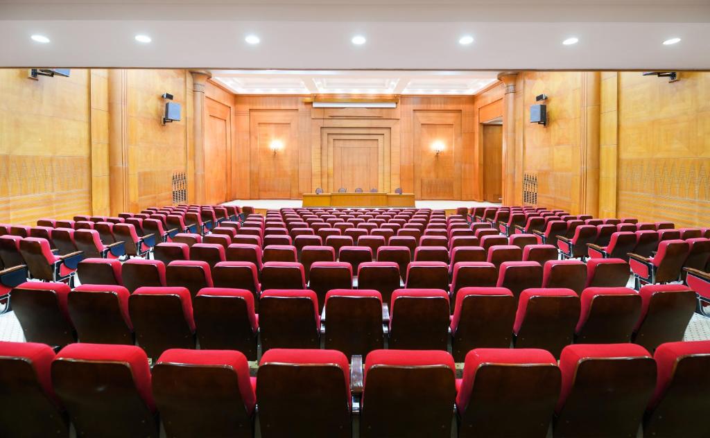 an empty lecture hall with red chairs and a podium at Tolip Aswan Hotel in Aswan