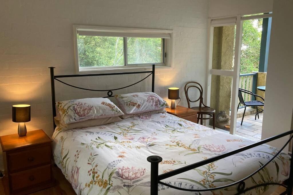 sypialnia z łóżkiem, 2 lampami i oknem w obiekcie Kookaburra Retreat w mieście Nelson Bay