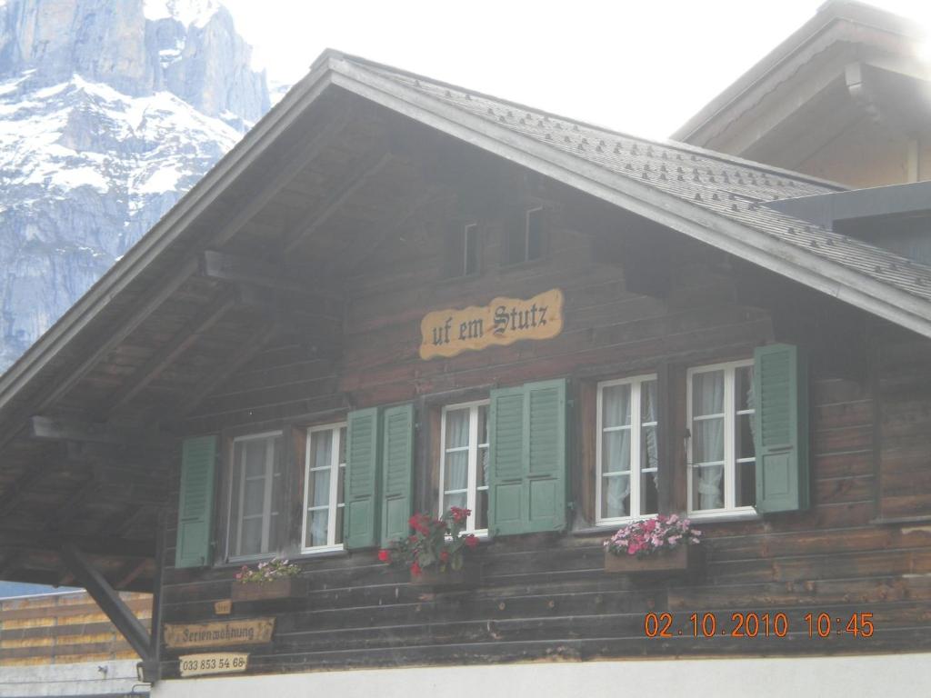 a building with green windows and a sign that reads off an attic at Chalet uf em Stutz 1 in Grindelwald