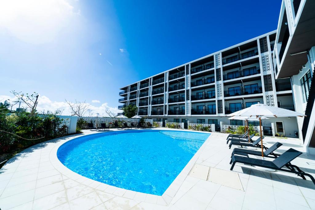 a swimming pool in front of a building at Hotel Torifito Miyakojima Resort in Miyako-jima