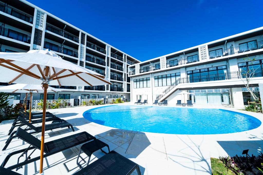 a swimming pool in front of a building at Hotel Torifito Miyakojima Resort in Miyako-jima