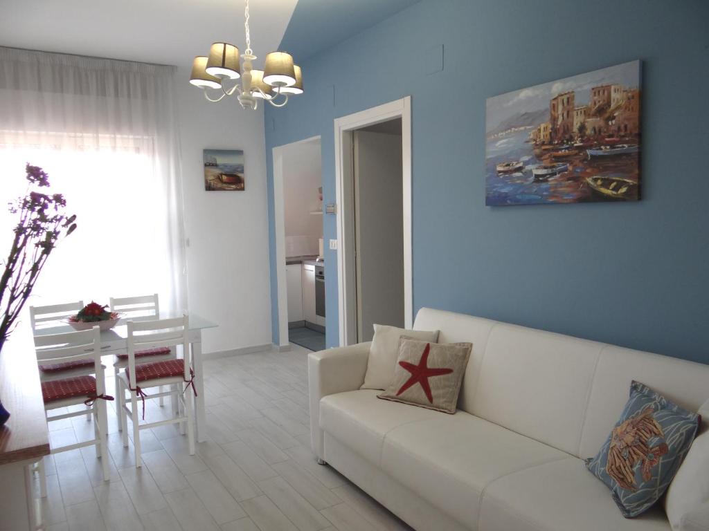 a living room with a white couch and a table at Appartamento vista mare in Martinsicuro