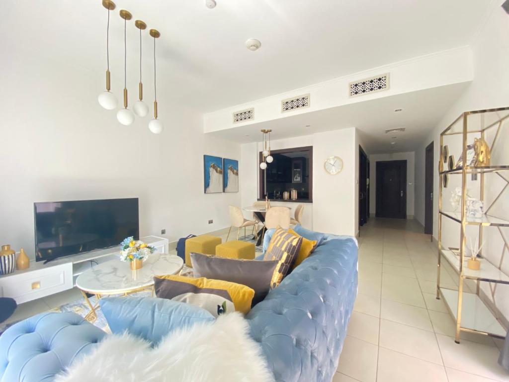 a living room with a blue couch and a tv at Durrani Homes - Old Town Lux 1 bed Besides Dubai Mall in Dubai