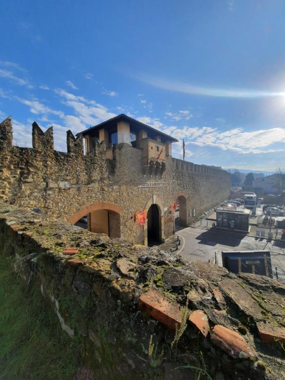 una vieja pared de piedra con un edificio encima en The Homestay - Arezzo en Arezzo