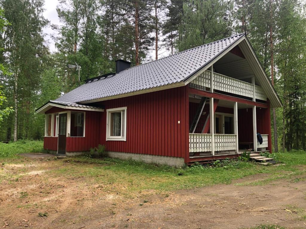 a red house in the middle of a forest at Lupiini in Savonlinna