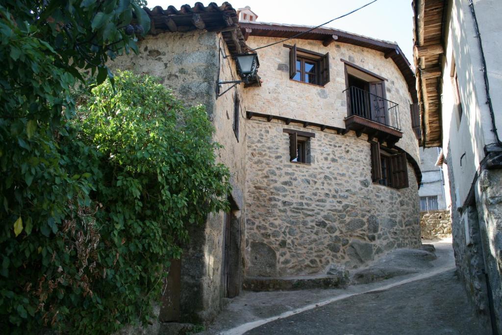 un antiguo edificio de piedra en una calle en Casa Cristina en Miranda del Castañar