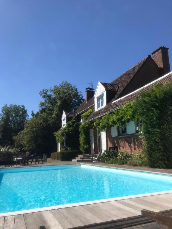 une piscine devant une maison dans l'établissement Les Glycines, à Croix