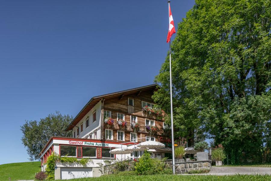 ein großes Gebäude mit einer Flagge davor in der Unterkunft Hotel Frohe Aussicht in Weissbad
