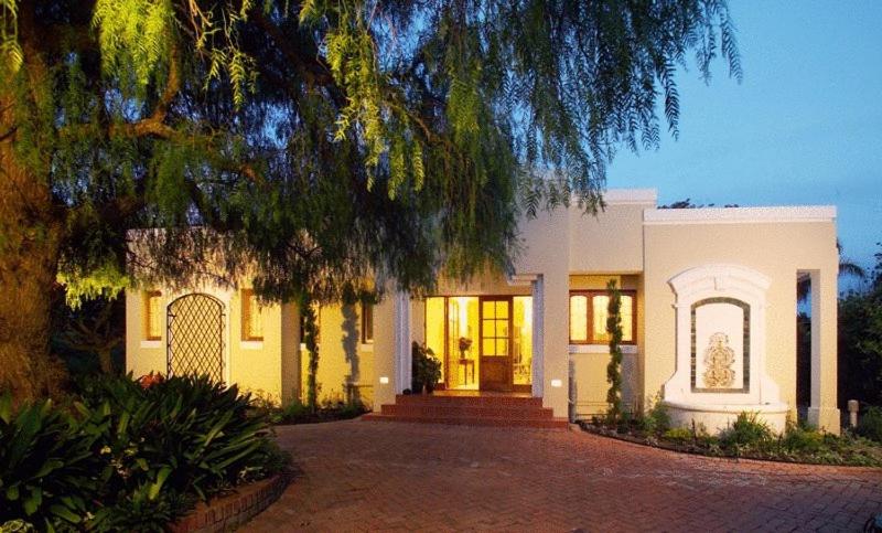 una casa blanca con un árbol y una entrada en Lemon Tree Lane, en Port Elizabeth