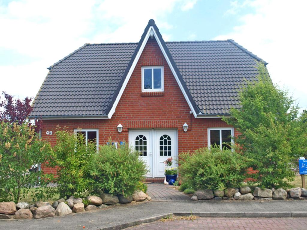 a red brick house with a black roof at Apartments Kirsebek in Kappeln