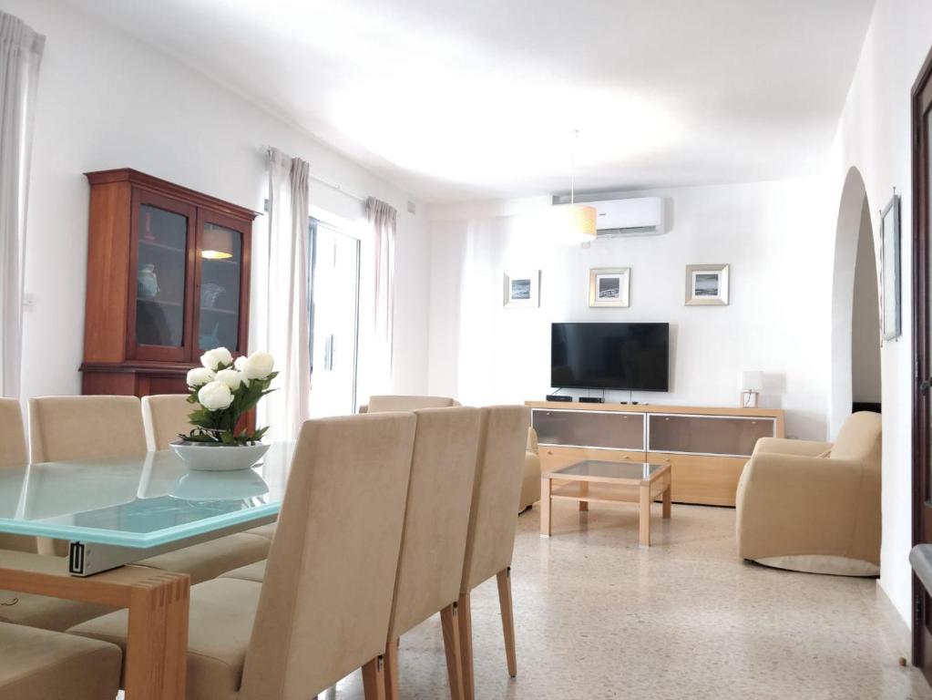 a living room with a table with chairs and a television at Large apartment close to rocky beach MCRE1-1 in Sliema