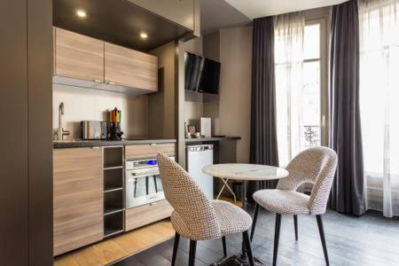 a kitchen with a table and chairs in a kitchen at CMG - Deluxe Tour Eiffel - 22 in Paris