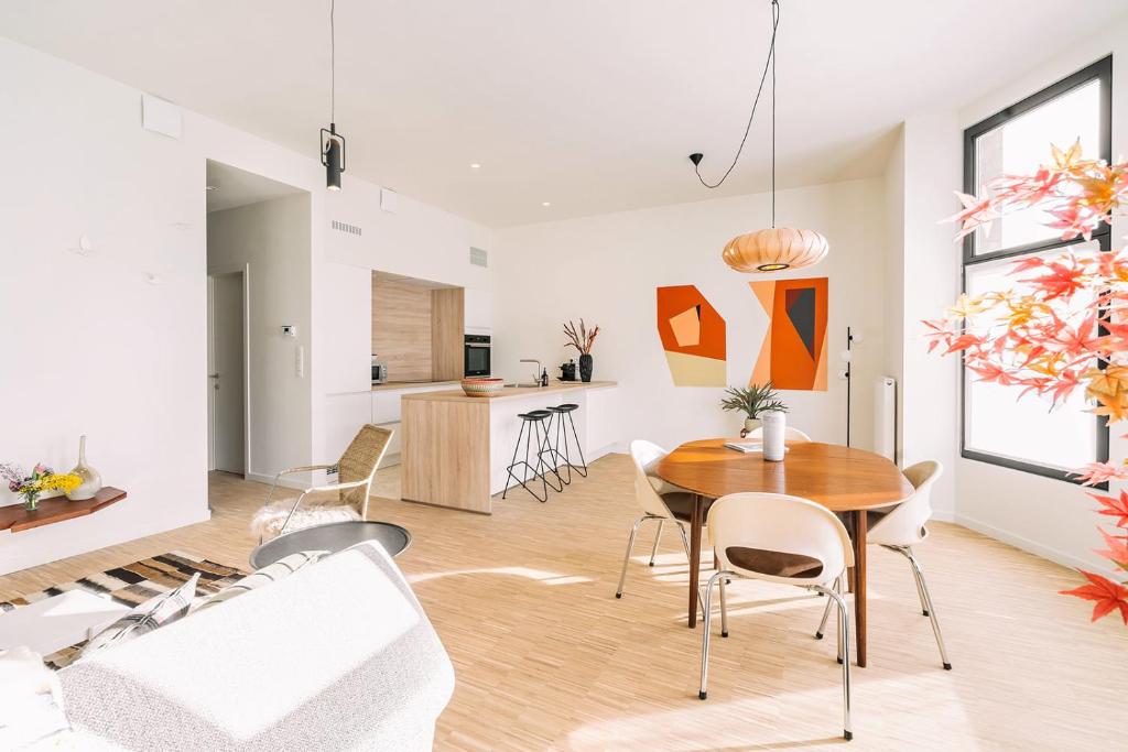 een eetkamer en een woonkamer met een tafel en stoelen bij Smartflats - Avenue Antwerp in Antwerpen