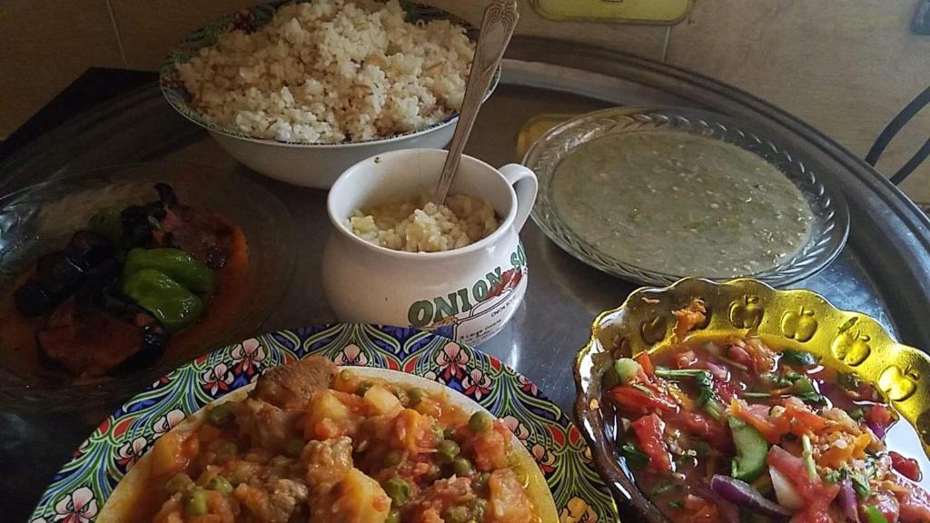 a table topped with plates of food and rice at Shipa's nubian house in Aswan