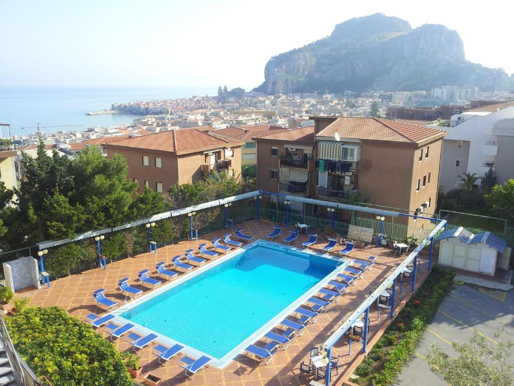 een zwembad met ligstoelen en een resort bij Hotel Villa Belvedere in Cefalù