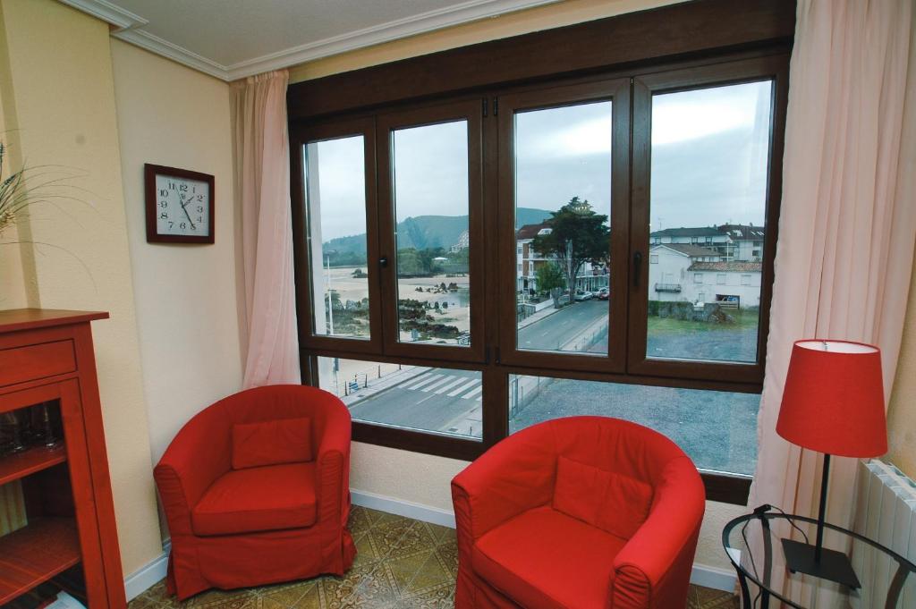 Cette chambre dispose de deux chaises rouges et d'une grande fenêtre. dans l'établissement Perez del Molino - 5806, à Isla