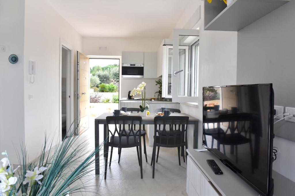 eine Küche mit einem Tisch und Stühlen im Zimmer in der Unterkunft Geranio Apartment - Villaggio di Mary in Locorotondo