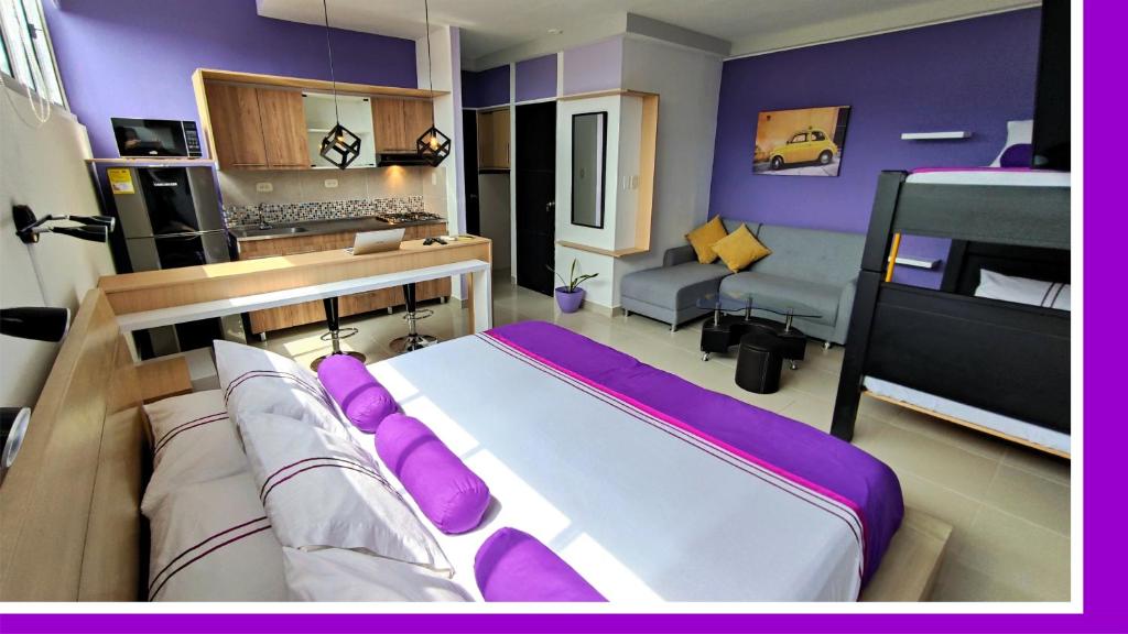 a bedroom with a large bed with purple pillows at HOTEL COLOURS Cali in Cali