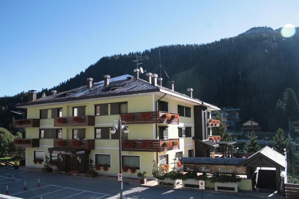 un grand bâtiment en face d'une montagne dans l'établissement Hotel Cristallo, à Madonna di Campiglio