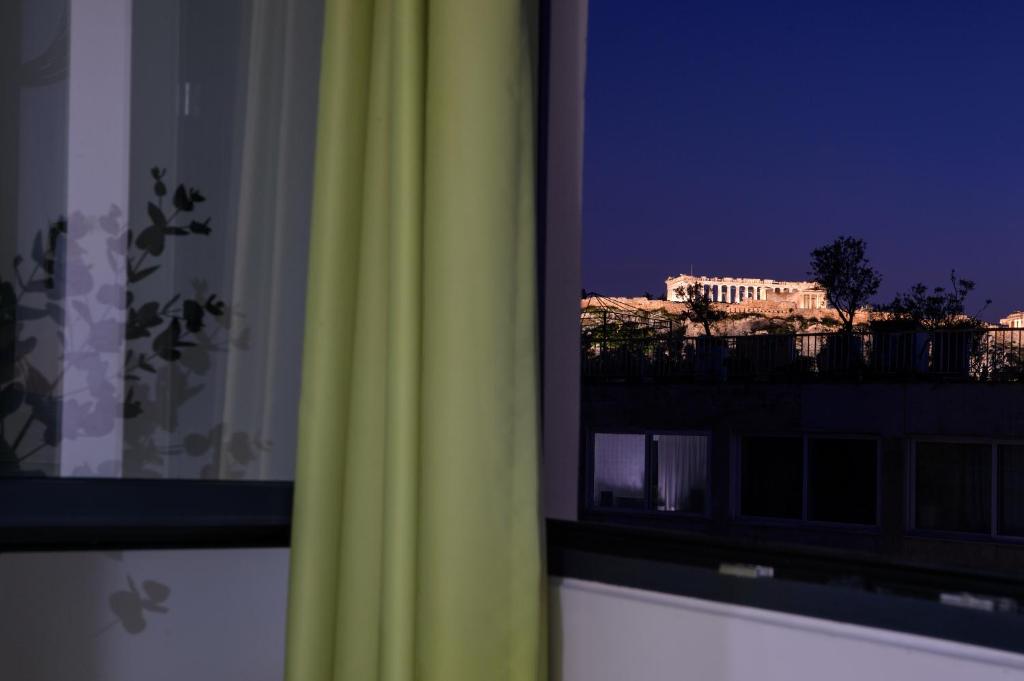 Athens Starlight Hotel في أثينا: نافذة مطلة على مبنى في الليل