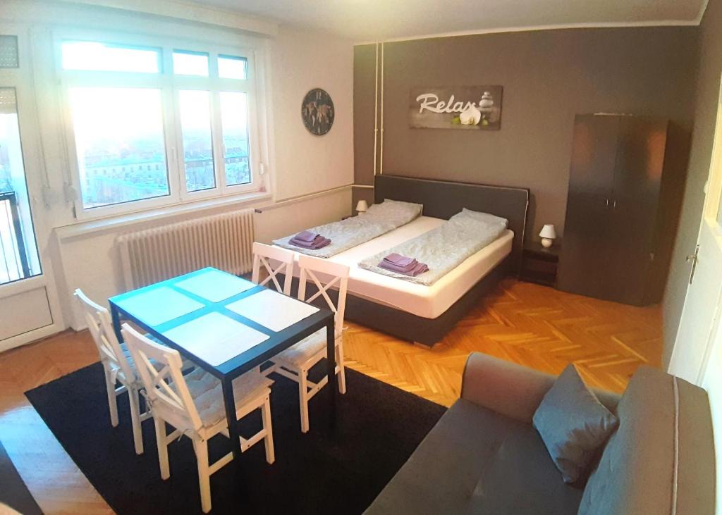 a small room with a bed and a table and chairs at Bálint Apartman - In the heart of Miskolc in Miskolc