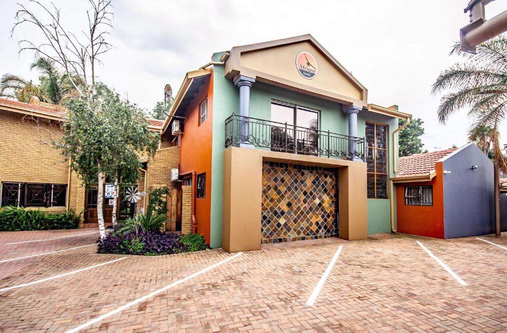 a colorful house with a garage in a parking lot at Sunward Park Guest House & Conference Center in Boksburg