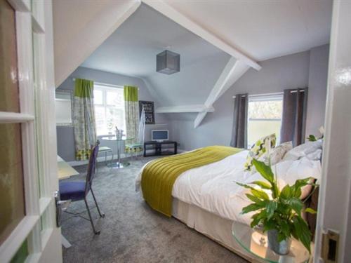 a bedroom with a bed and a table and a desk at James' Place at Brynawel in Merthyr Tydfil