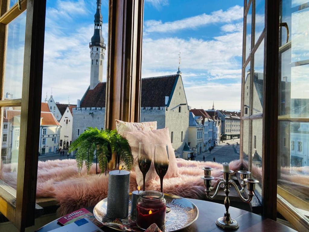 a table with wine glasses and a view of a city at Dream Stay - Main Square Apartment with Picturesque View in Tallinn