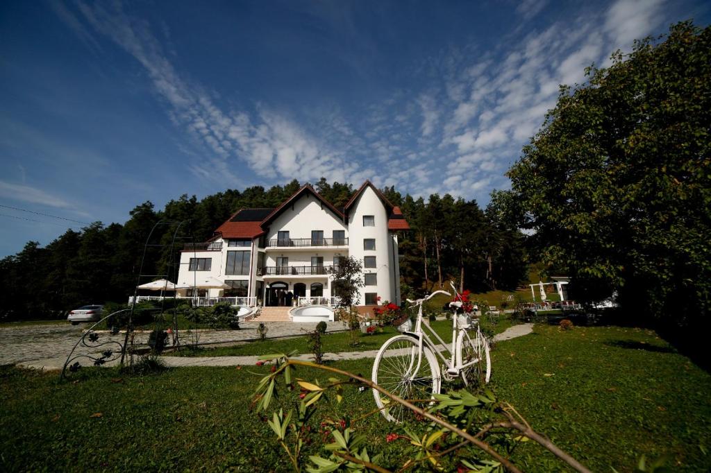 a white bike parked in front of a large house at Pensiunea Baroc in Braşov