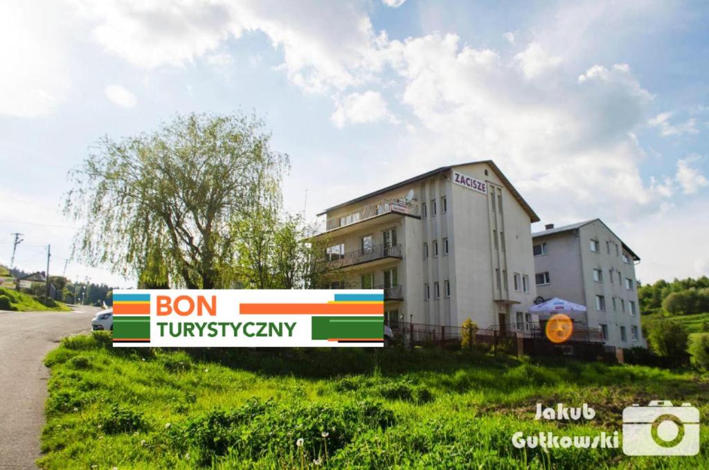 a building with a sign on the side of a road at Zajazd Zacisze in Rymanów-Zdrój