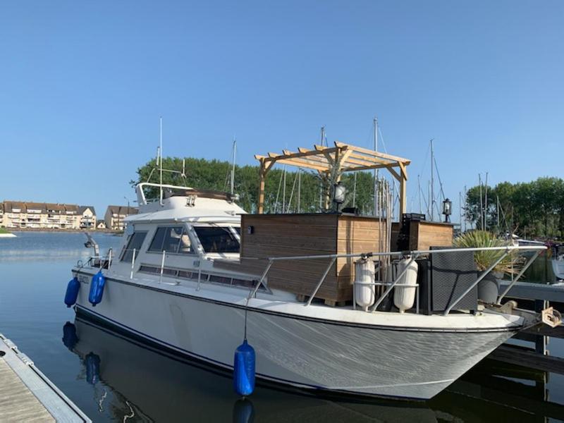 una barca bianca è ormeggiata al molo di Magnifique bateau maison a Ouistreham