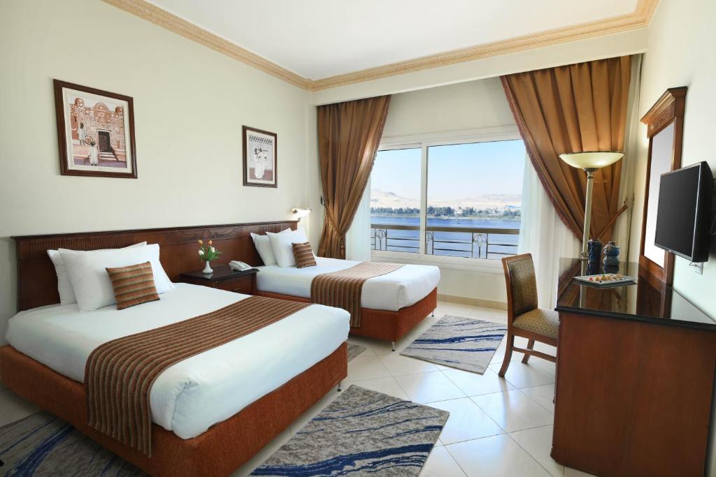 a hotel room with two beds and a window at Tolip Aswan Hotel in Aswan