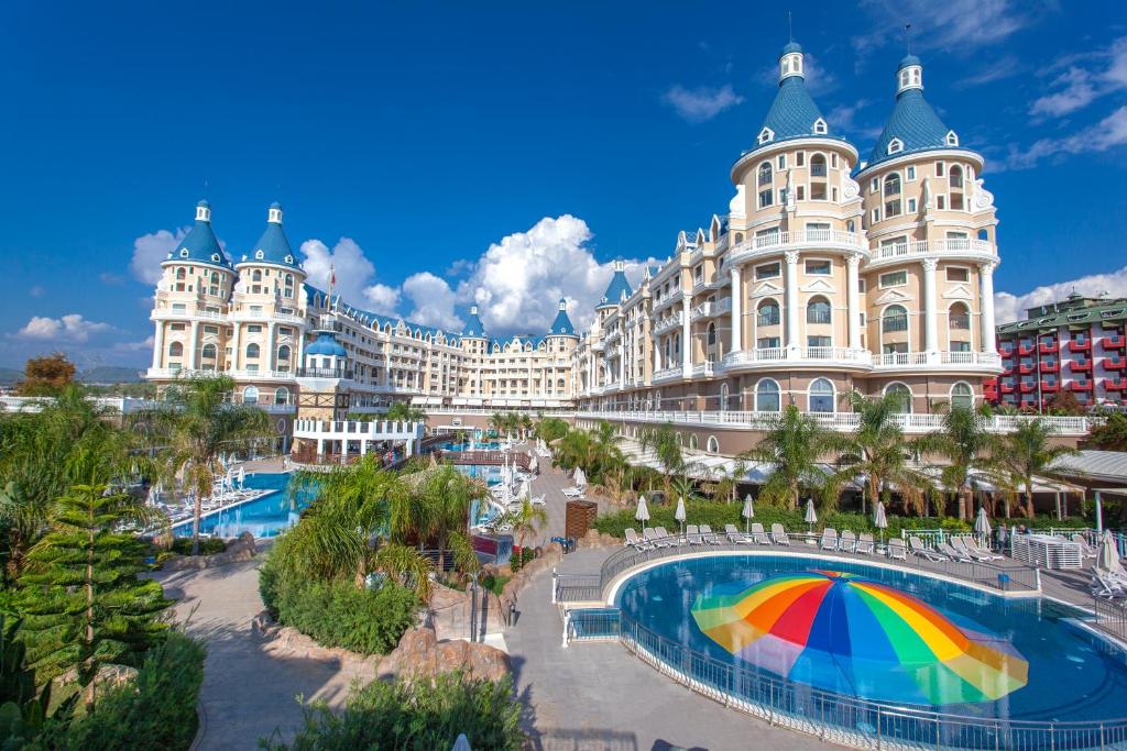 Haydarpasha Palace Hotel في أفسالار: مبنى كبير أمامه مظلة قزاز