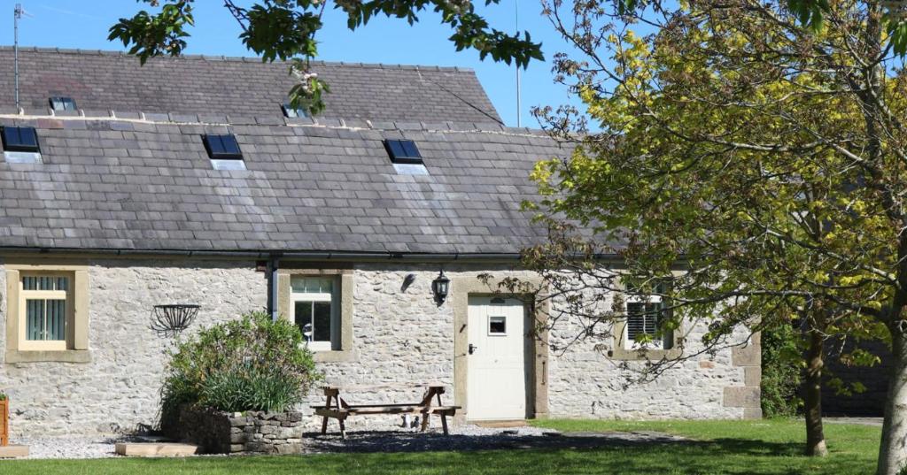 a stone house with a dog on the roof at Unicorn Cottage in Bakewell