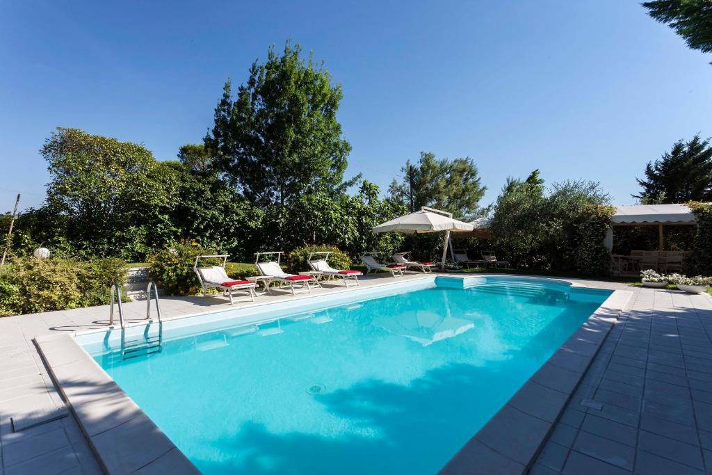 a swimming pool with chairs and an umbrella at Villa Tramonto luxury apartment with private swimming pool in Pesaro