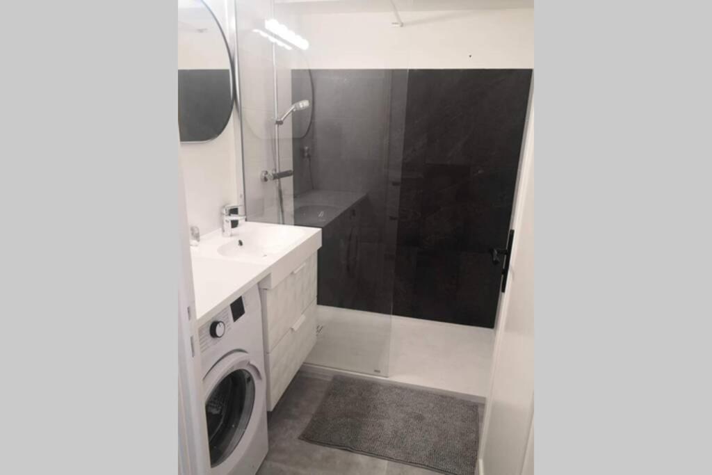 a bathroom with a sink and a washing machine at Vue mer port de garavan in Menton