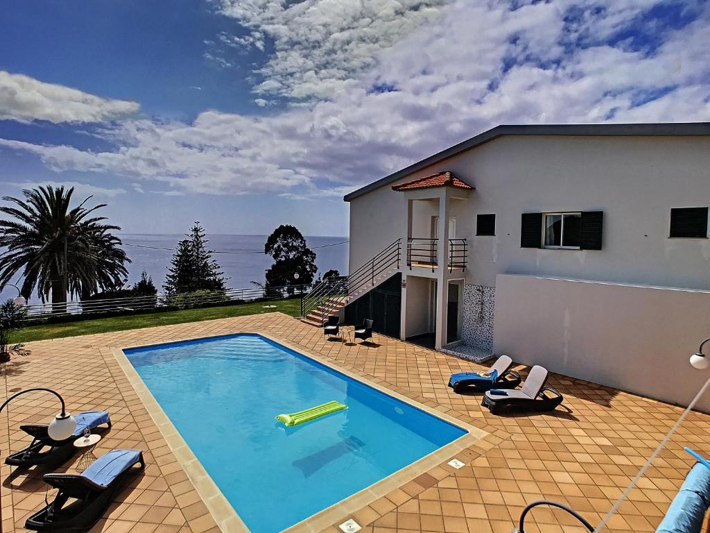 a swimming pool in front of a house at Villa Prainha by LovelyStay in Caniçal