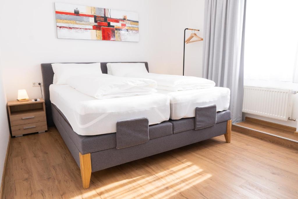 een slaapkamer met een groot bed met witte lakens bij Hotel Dortmunder Hof in Würzburg