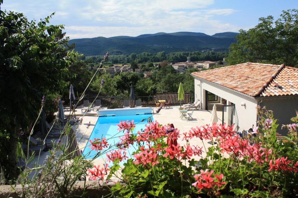 a villa with a swimming pool and flowers at Gîtes Domaine de la Barnerie in Saint Alban Auriolles