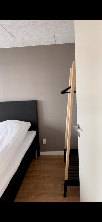 a bedroom with a white bed and a ladder at Surfers Paradise Apartments in Hvide Sande