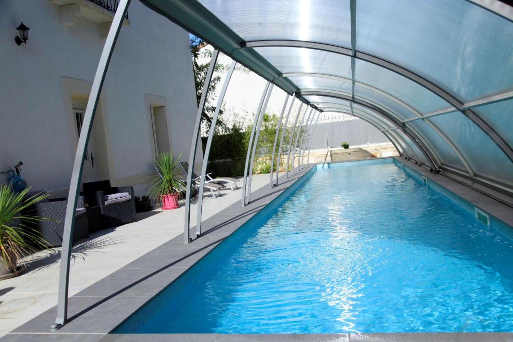 a swimming pool with an arch over it at Le Clos du Théron, chambre d'hôte in Cournonterral