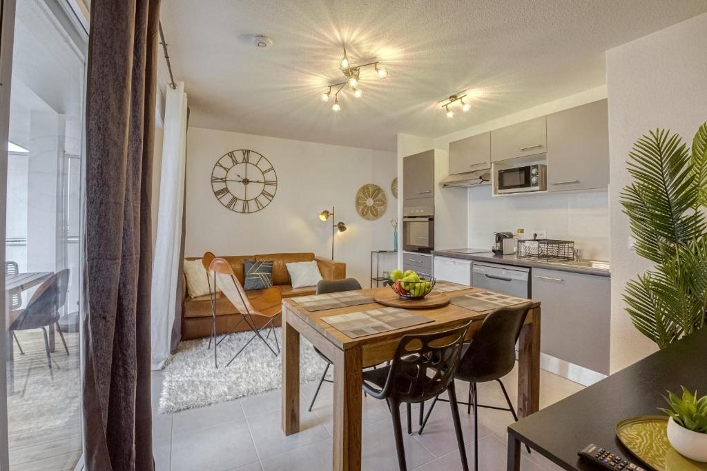 a kitchen and a living room with a table and chairs at Voltaire in Toulouse