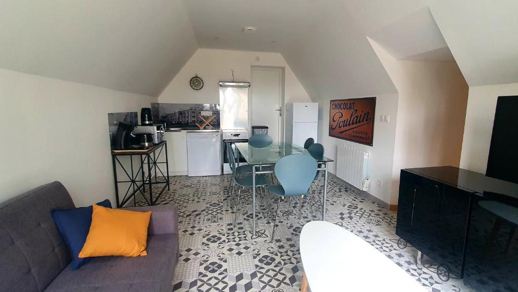 a living room with a couch and a table with chairs at Appartement "POULAIN" en Centre-ville linge inclus in Blois