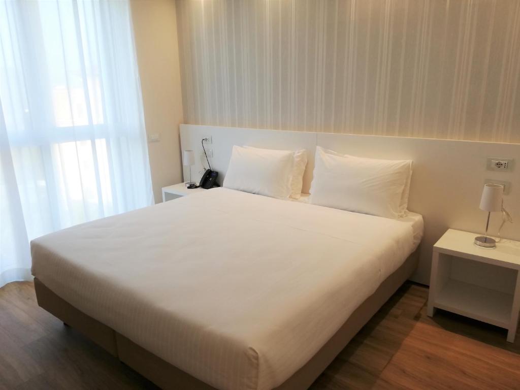 Łóżko lub łóżka w pokoju w obiekcie Novo Hotel Rossi
